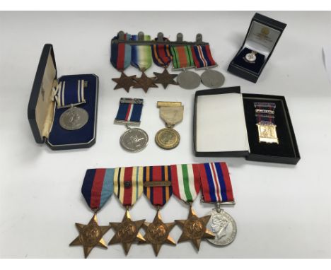 A Collection of WW2 service medals; a Naval rosette and bar awarded to Mr R Newcombe, and other medals including the Malta Cr