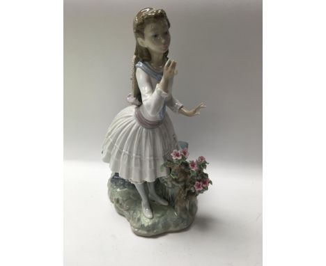 A Lladro figure in the form of a girl beside a rose bush . With box .