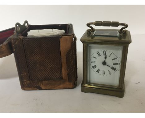 A small brass cased carriage clock in a traveling case with key seen working.