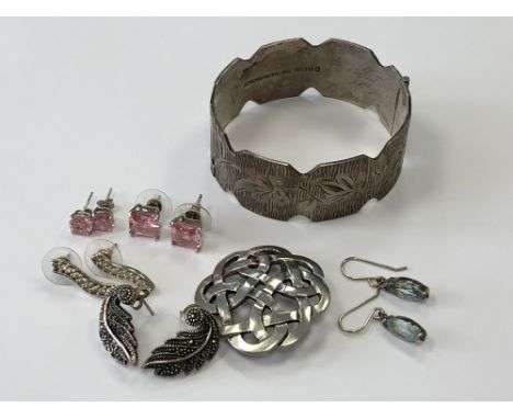 A silver bangle, Celtic brooch and five pairs of silver earrings. 