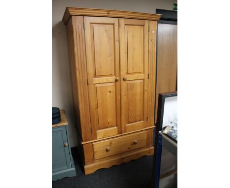 A pine double door wardrobe fitted a drawer  CONDITION REPORT: Height 192.5 cm., depth 59.5 cm, width 110.5 cm. Internal rail