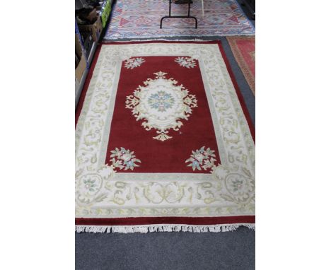 A fringed woolen carpet on red ground 