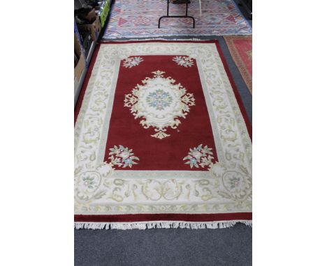 A fringed woolen carpet on red ground 