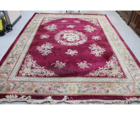 A Chinese floral embossed carpet on maroon ground 