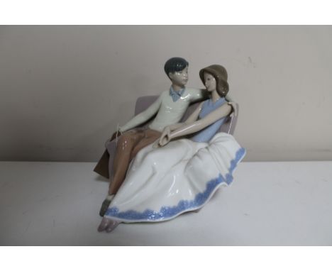 A Nao figure of a couple sat on a couch 