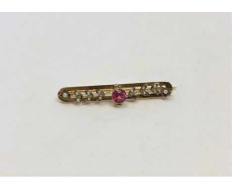 A 9ct gold seed pearl bar brooch set with a ruby coloured stone, 3.6g.
