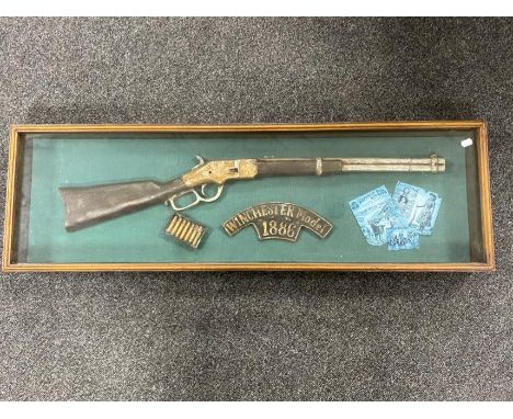 A Winchester model 1886 rifle montage in display case  CONDITION REPORT: 106.5 cm x 33 cm. A fantasy item.