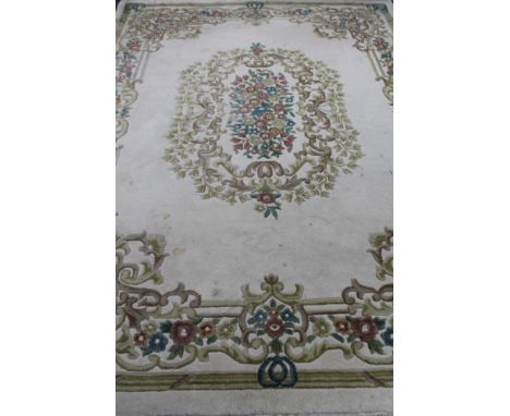An Indian floral fringed carpet on cream ground  CONDITION REPORT: 275 cm x 367 cm. Mostly fair condition, it has been used a