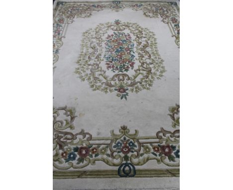 An Indian floral fringed carpet on cream ground  CONDITION REPORT: 275 cm x 367 cm. Mostly fair condition, it has been used a