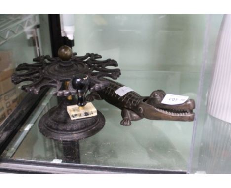A NOVELTY CROCODILE NUTCRACKER together with a metal revolving rack 