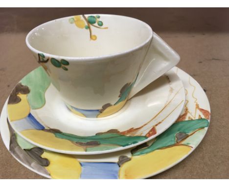 A Clarice Cliff trio decorated with house and trees .