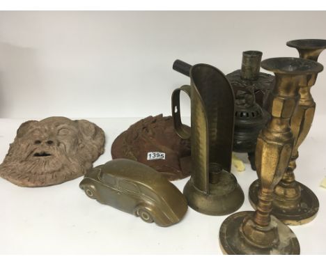 Two earthenware wall plaques an unusual treen oak candle stick a cast brass car and other ornaments (a lot)