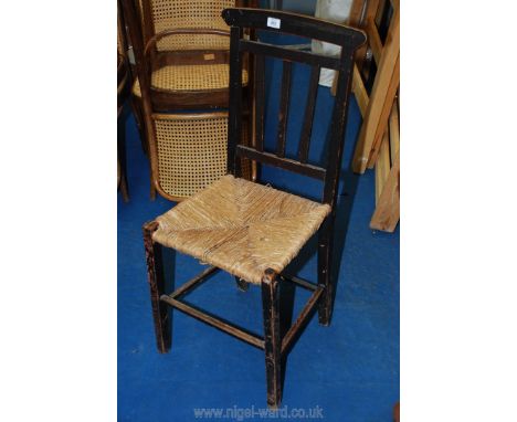 A seagrass seated stick back style chair having finely carved detail hardly visible on camera.