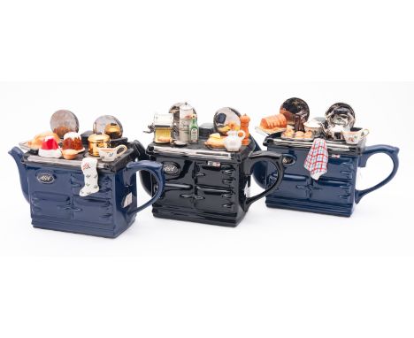 Three Teapottery novelty AGA teapots each modelled with a surface full of kitchenalia, printed marks, 30cm long.

