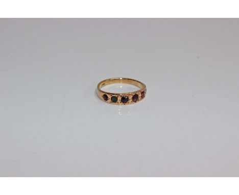 An 18ct gold ring. Star set to band with single cut garnet, emerald, tourmaline ,amethyst, ruby and diamond. 2.6g Size N