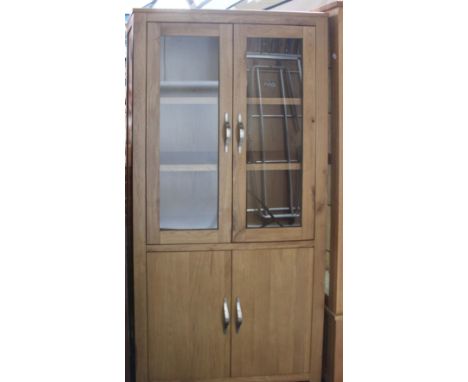 A light oak, glazed-top cupboard (h: 180cm w: 90cm d: 35) with brushed chrome handles. 