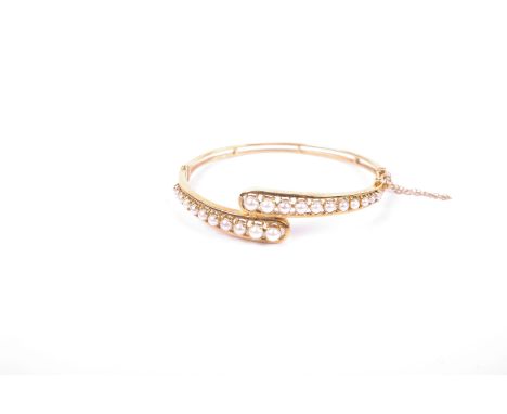 A 9ct gold bangle bracelet set with two lines of graduated split pearls. 15g 