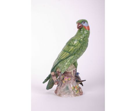 A Potschapel (Dresden) ceramic model of a green falcon with prey clutched in one claw, titled to side of base, 'XT' mark and 