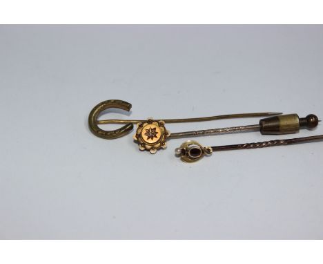 Two 15ct tie pins , the first in the arts and crafts style with collet set oval red garnet and seed pearl knop together with 