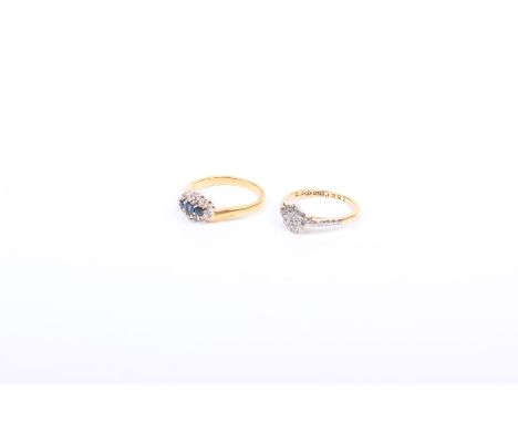 Two 18ct gold rings the first a diamond illusion set flower ring together with a three stone sapphire ring with single cut di