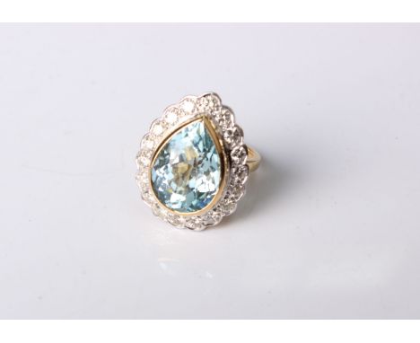 An aquamarine and diamond dress ring.The pear cut aquamarine estimated to weigh 6.84 carats within a surround of brilliant cu