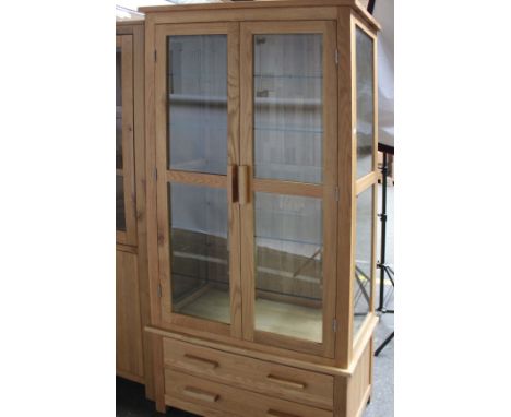 A light oak, glazed display cabinet (h: 185 w: 90cm d: 40cm) with five glass shelves and two shallow drawers. 