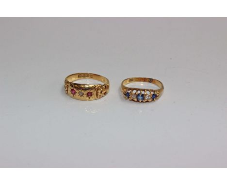 Two 18ct gold gem set rings. An 18ct gold band with central star set old cut diamond with star set single cut ruby accents an