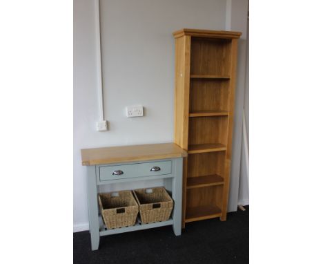 A tall light oak bookcase (h: 180cm w: 55cm d: 25cm) and a painted wooden basket console table (h: 80cm w: 86cm d: 35cm)