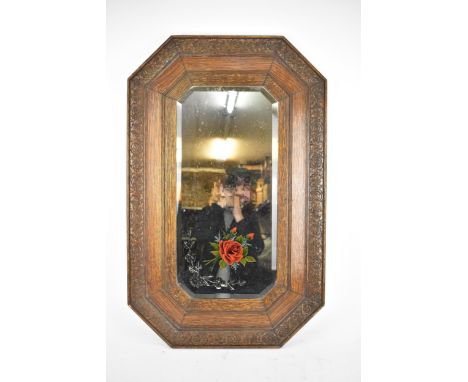 A mid-century carved oak framed gypsy mirror, rectangular mirrored plate with canted corners, having engraved floral and reve