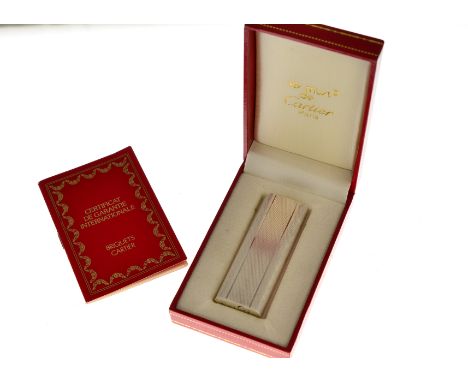 Les Must de Cartier stainless lighter with an engine turned design, numbered 450331, with original guarantee dated 1992 &amp;