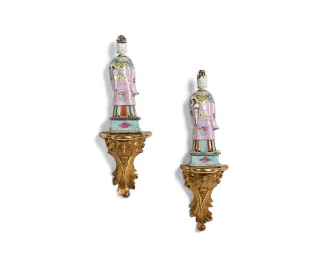 A PAIR OF CHINESE FAMILLE ROSE STANDING FIGURES 19TH CENTURY 22.5cm high  Together with a pair of giltwood wall brackets 15cm