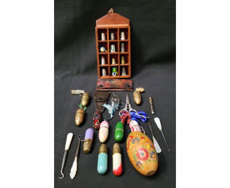 SELECTION OF SEWING ACCOUTREMENTScomprising various thimbles in wooden display case, including three silver examples and an e