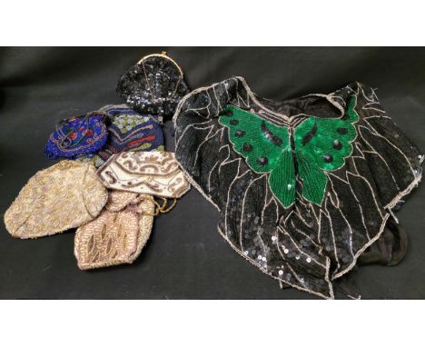 BLACK BEADED SHOULDER SHRUG with tassel detail; together with a sequinned butterfly decorated top; and six beaded evening bag