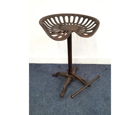 CAST IRON TRACTOR SEAT STOOLthe shaped and pierced seat on column support with footrest, 66.5cm high
