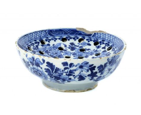 A DELFTWARE COLANDER BOWL, LONDON, C1770 freely painted with peony in diaper border, 23cm diam ++The rim chipped and typical 