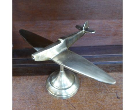 A brass model of a spitfire on stand 