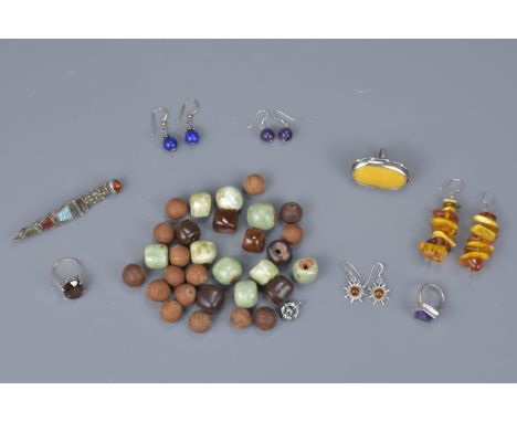 Three silver and white metal rings with a pair of amber star earrings, a pair of faceted amethyst bead earrings, lapis bead e