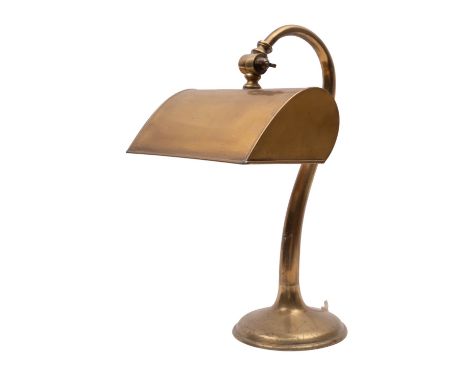 A brass desk lamp, early 20th century; with electrical fitment within an adjustable shade, on a serpentine stem to a domed ba