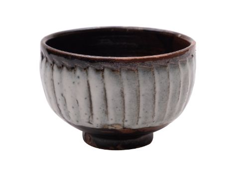 *David Leach [1911 - 2005] a stoneware bowl, of circular footed form the vertically incised exterior under an ivory band over