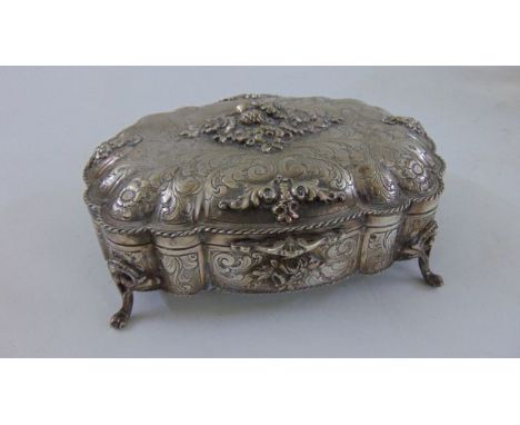 A Scandinavian silver trinket box with engraved and embossed detail, shaped outline and raised on four scrolled supports, 18 