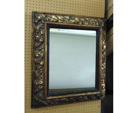 A rectangular wall mirror in an embossed and gilded cushion moulded frame, 60 cm max