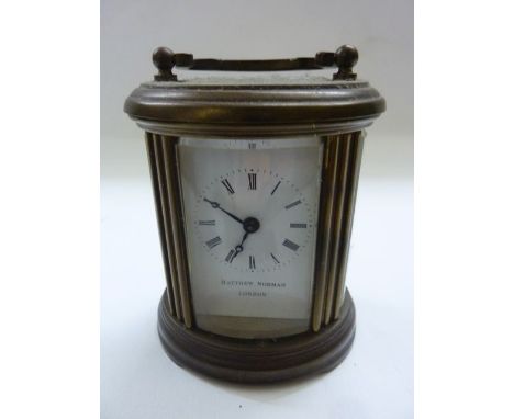 A small carriage clock by Matthew Norman, the oval case fitted with enamel dial and 8 day timepiece