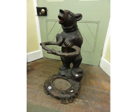 A Black Forest umbrella/stick stand in the form of a well modelled carved standing bear supporting an oval naturalistic mould