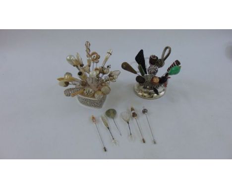 An embossed silver heart shaped hat pin cushion with trailing detail together with a further circular silver hat pin holder s