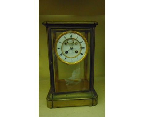 19th century brass framed four pane mantle clock with enamel dial and visible escapement and with mercury compensating pendul