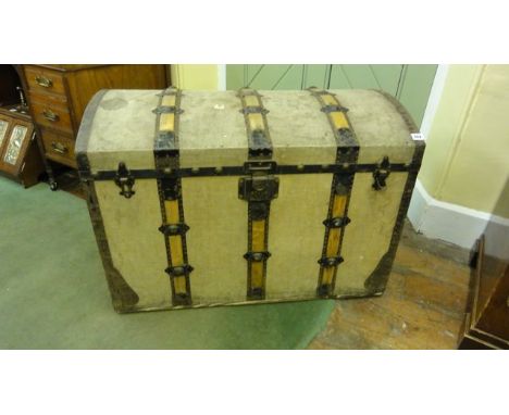 An early 20th century travelling trunk with domed lid, canvas covered with timber lathes and further steelwork complete with 