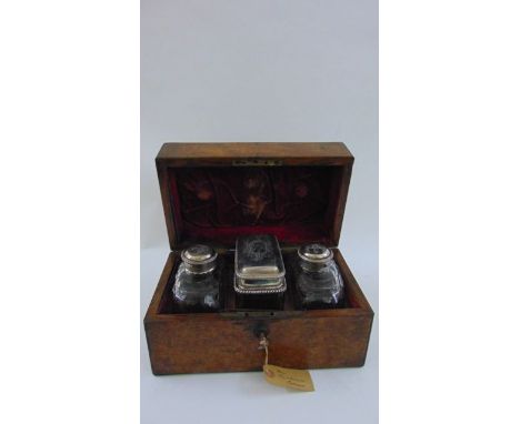A mid 19th century burr walnut caddy, the rising lid revealing a pair of cut glass caddies of shouldered form with plated gla
