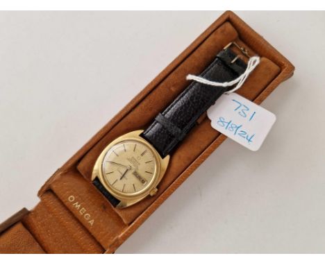 A GOLD OMEGA AUTOMATIC CHRONOMETER AUTOMATIC WRIST WATCH WITH GOLD OMEGA BUCKLE WITH DAY DATE APERTURE SECONDS SWEEP W/O IN O