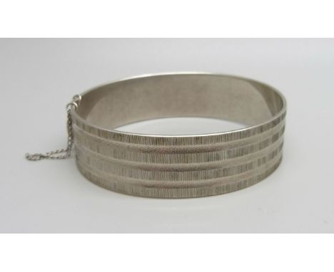 A silver bangle with engine turned design, 31g 