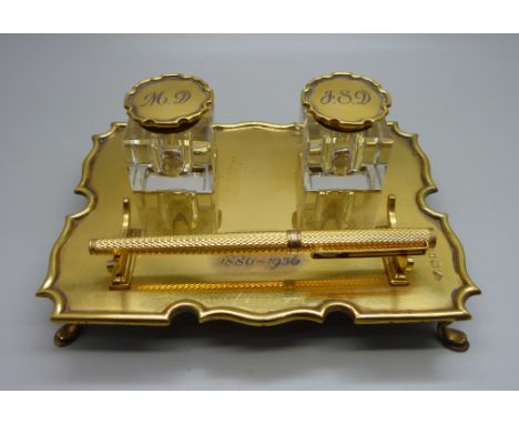 A silver gilt desk stand with two glass inkwells, London 1935, Goldsmiths &amp; Silversmiths, with inscription, base 245g, 16